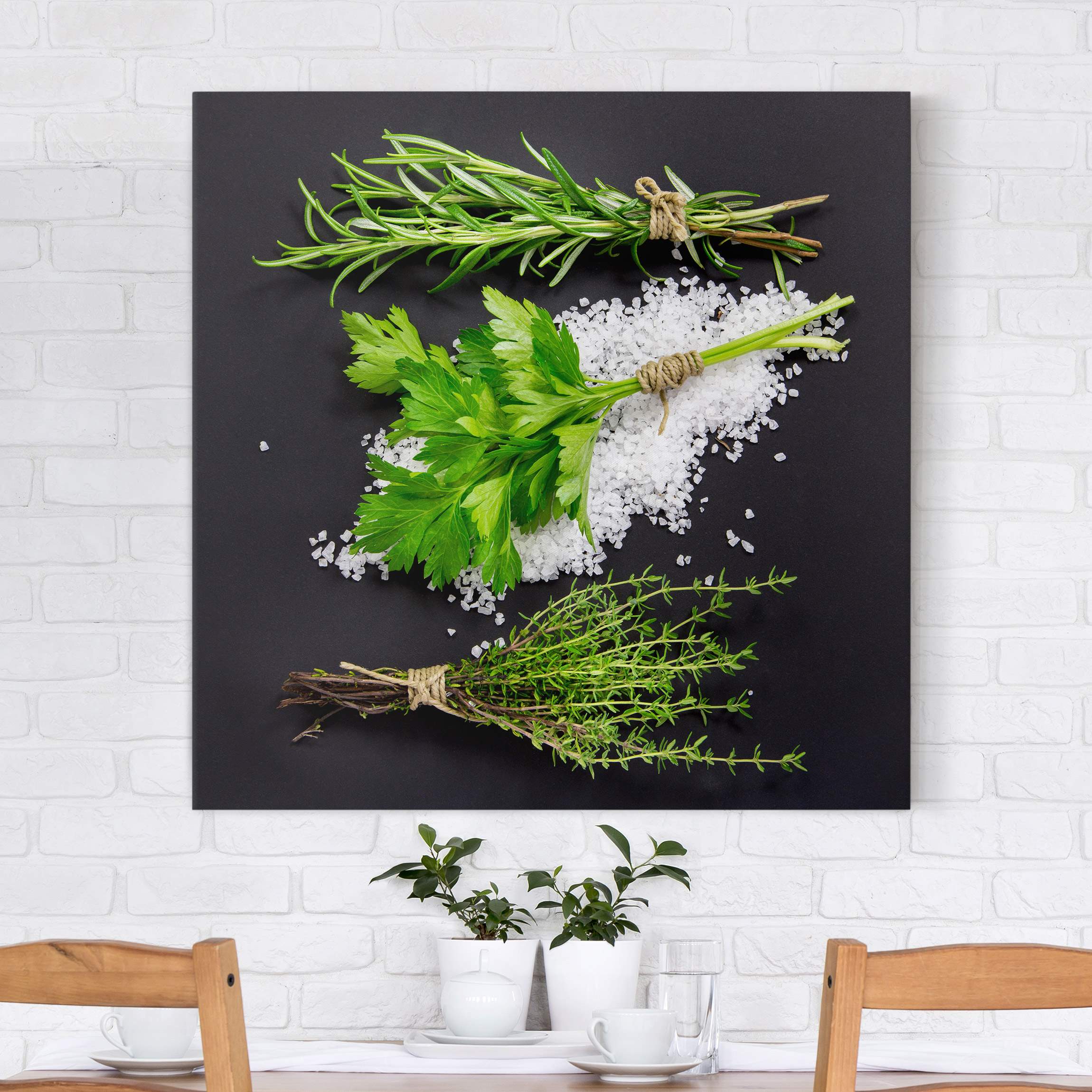 Leinwandbild Kräuter im Salzbett vor Schwarz