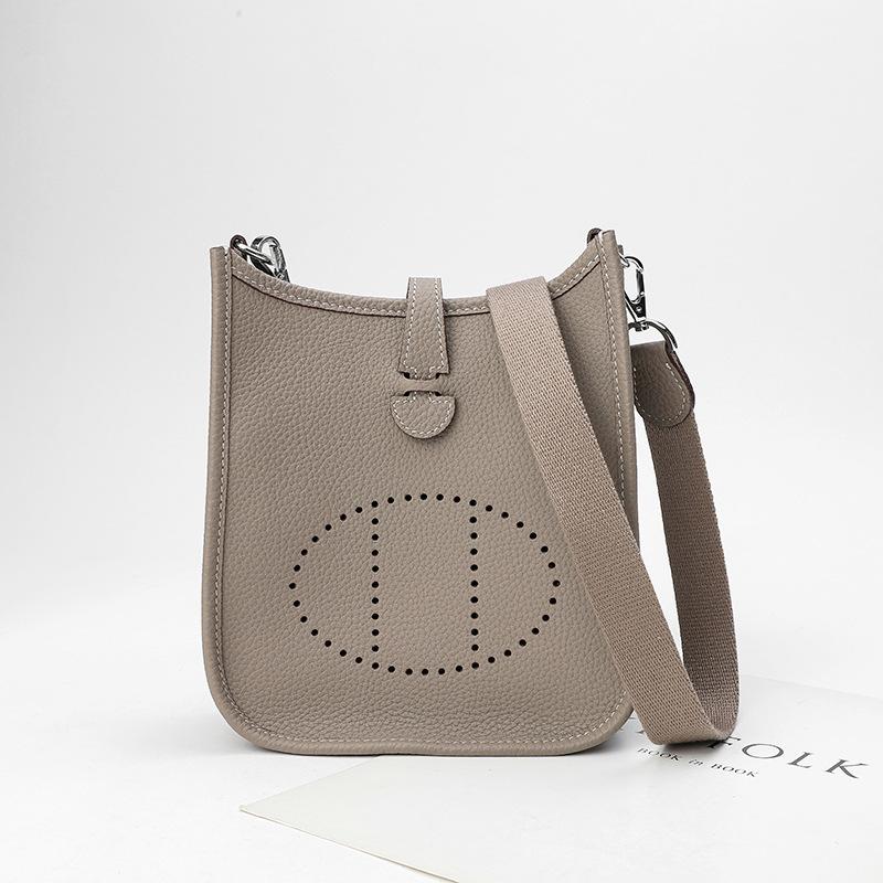 Fabrikgroßhandel erste Schicht Rindsleder Eimer Tasche Damen Tasche Litschi Muster Hohl Einzel Schulter Crossbody Tasche Hohl Design 22x9x23cm hellgrau